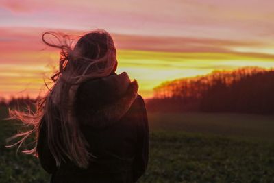 Rear view of woman looking at sunset