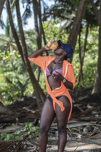 Woman standing by tree in forest