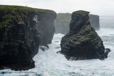 Rock formation on sea against sky