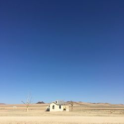 Scenic view of desert against clear blue sky