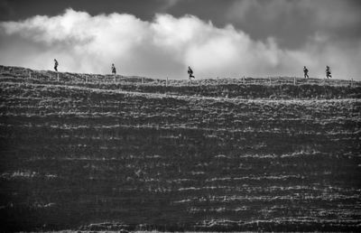 People running on land against sky