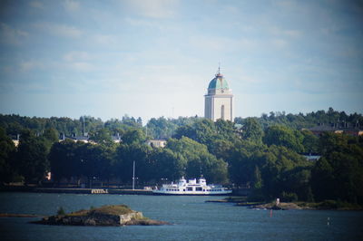 Scenic view of river by buildings against sky