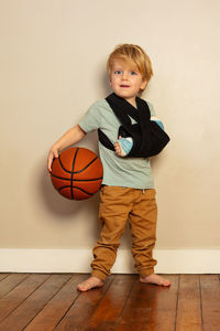 Portrait of cute boy standing against wall