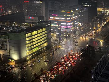 High angle view of illuminated city street and buildings at night