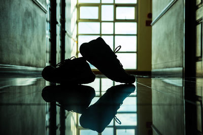 Reflection of pair of shoes on floor