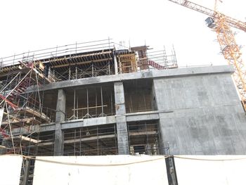 Low angle view of building under construction against sky