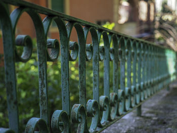 Close-up of metal railing against fence