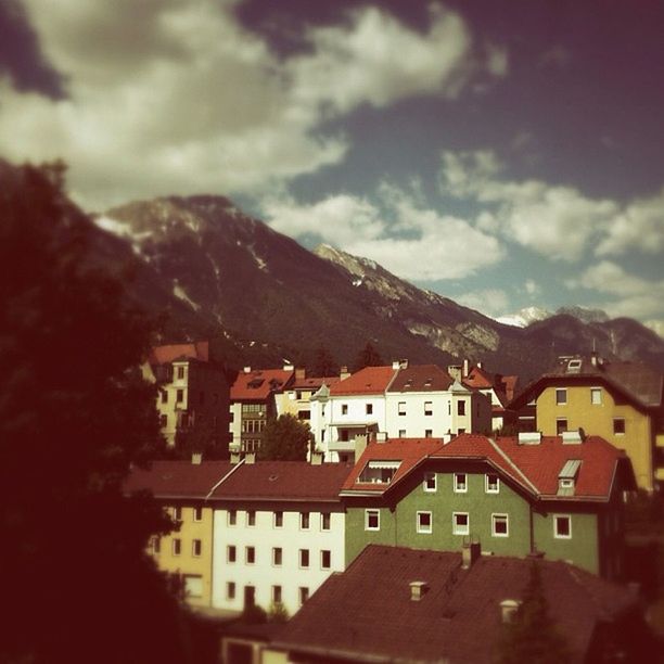 building exterior, architecture, built structure, house, residential structure, mountain, sky, residential building, residential district, roof, town, townscape, cloud - sky, high angle view, cloud, mountain range, tree, city, crowded, day