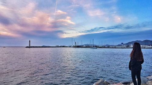 Rear view of woman looking at sea against sky