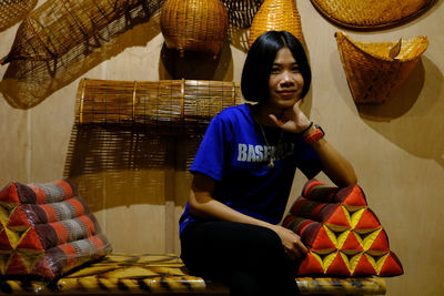 Portrait of smiling young woman sitting indoors