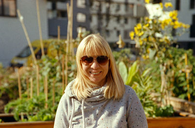 Portrait of smiling mature woman wearing sunglasses in city