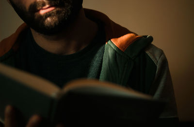 Midsection of man holding book