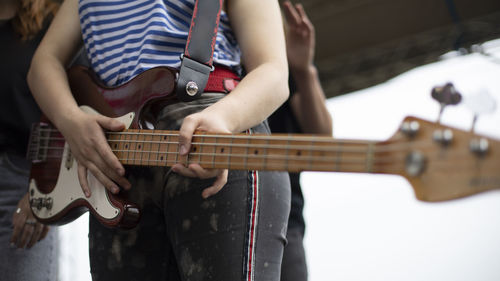 Midsection of man playing guitar