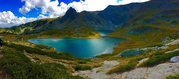 Scenic shot of calm lake against rocky mountains