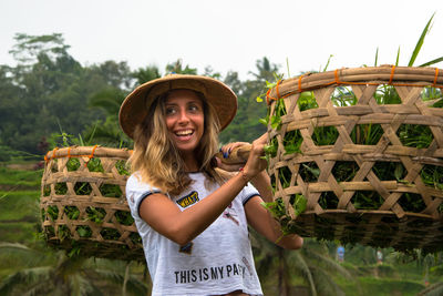 Portrait of smiling young woman standing in basket