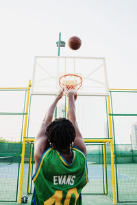 Low angle view of boy playing basketball hoop