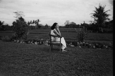 Rear view of man sitting on bench in park