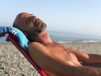 Midsection of man at beach against sky