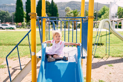 Full length of woman sitting at playground