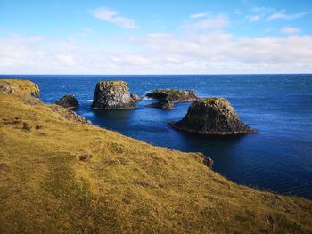 Scenic view of rocks in sea against sky