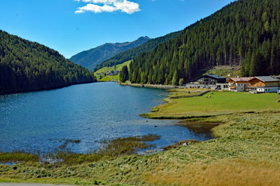 Scenic view of lake by houses against sky