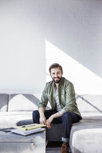 Portrait of smiling businessman sitting on sofa in office