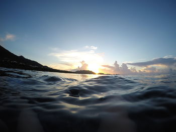 Surface level of sea against sky during sunset