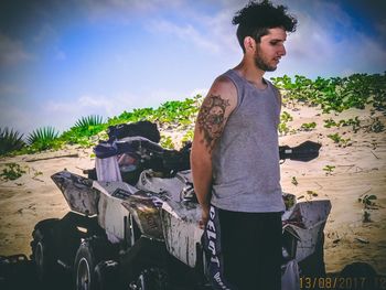 Young man standing against sky