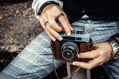 Close-up of photographer using analog photo camera.