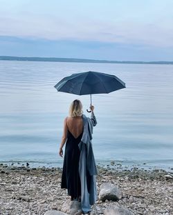 Elegant woman with umbrella looking in the se