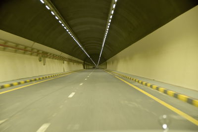 Empty road in illuminated tunnel