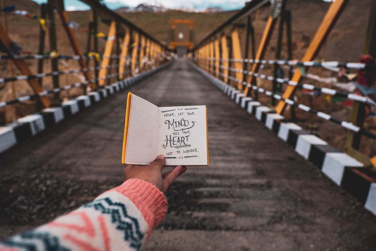 LOW SECTION OF PERSON WITH TEXT ON FOOTBRIDGE AT RAILROAD STATION