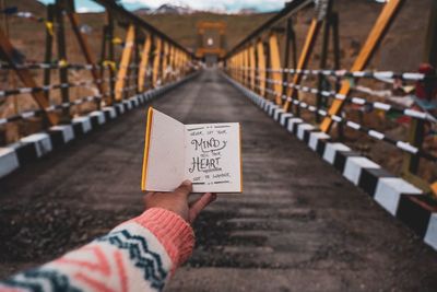 Low section of person with text on footbridge