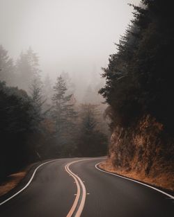 Road amidst trees against sky
