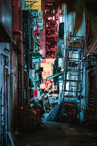 Illuminated alley amidst buildings in city