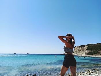 Man standing on beach against clear sky