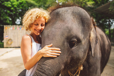 Woman standing by elephant