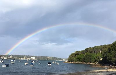 Scenic view of rainbow over sea against sky