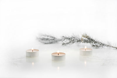 Close-up of illuminated tea light candles in winter