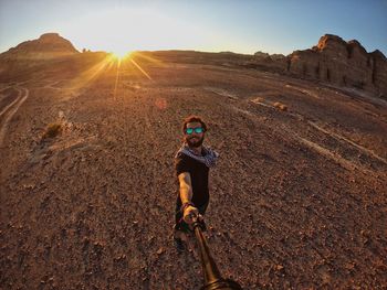 Portrait of man on field in desert against sky