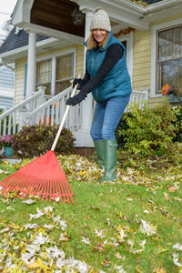 Woman holding umbrella standing in yard