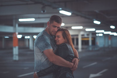 Couple embracing in parking lot