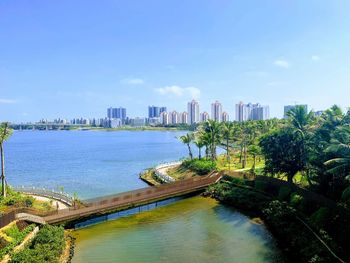 Scenic view of river by buildings against sky