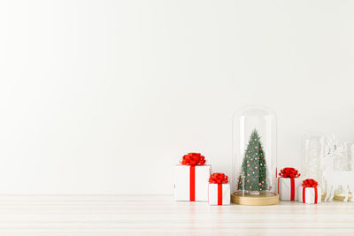 Red christmas decoration on table against white background