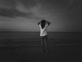 Rear view of woman standing on beach