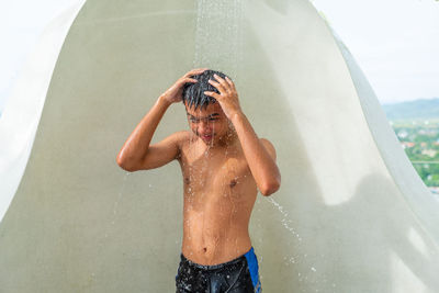 Midsection of shirtless boy in water