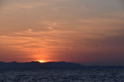 Scenic view of sea against orange sky