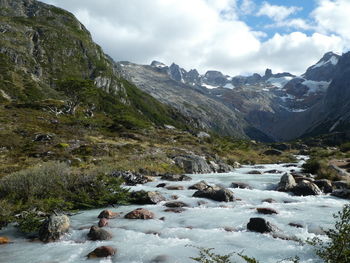 Scenic view of river and mountains against sky