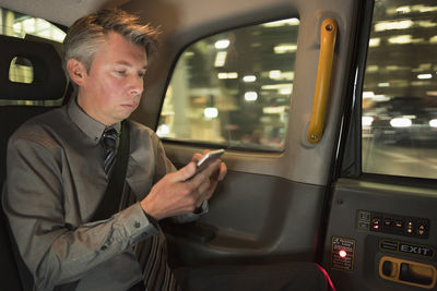 Man using mobile phone while sitting in car