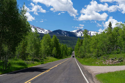 Road amidst trees against sky